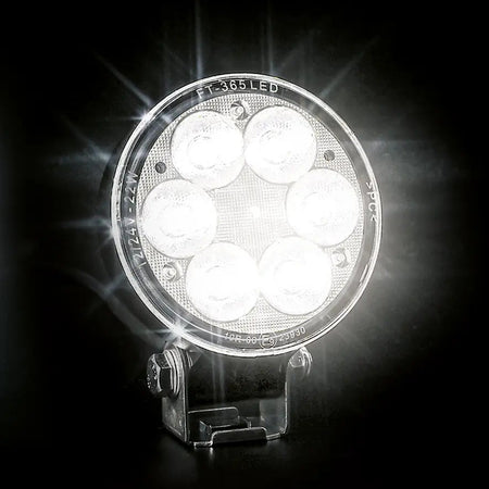 Round LED work light FT-365 shining brightly on black background