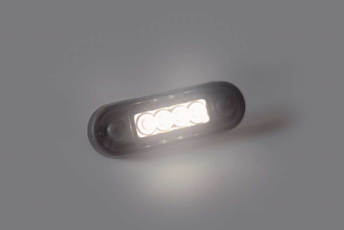 LED oval marker light glowing on a plain gray background